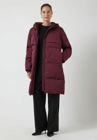 Burgunderfarget dunjakke med hette, glidelåslukking og store frontlommer. Materialet har en glatt tekstur og en litt skinnende finish.