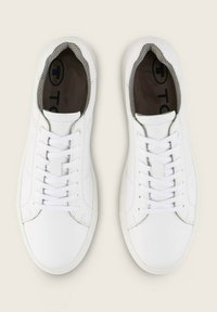 Weiße Leder-Sneaker mit glatter Oberfläche. Mit flachen weißen Schnürsenkeln, abgerundeter Zehenpartie und einer strukturierten Mesh-Fütterung um den Knöchel.