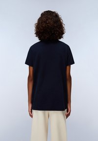 Camiseta de algodón azul marino con un ajuste relajado, mangas cortas y un escote redondo, vista desde la parte posterior sobre un fondo claro.