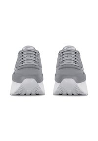 Pár sivých tenísk Reebok s bielymi hrubými podrážkami a šnúrkami, zobrazené spredu na bielom pozadí.