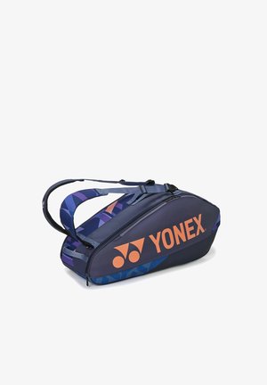 Marineblauer Yonex-Sporttasche mit orangefarbenem Logo, geometrisch gemusterten Tragegurten und Reißverschlussfächern, entworfen zum Tragen von Schlägern und Ausrüstung.