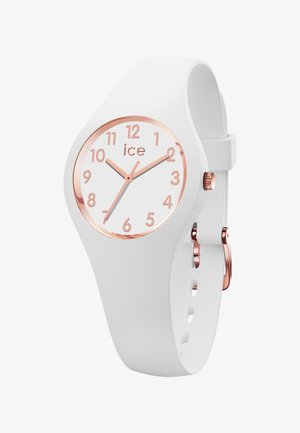 Orologio in silicone bianco con quadrante rotondo, indici e lancette color oro rosa. Presenta una corona e una fibbia ad ardiglione in oro rosa coordinati.