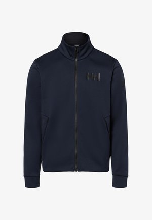 Chaqueta con cremallera en azul marino, fabricada en tejido suave, con un cuello alto, dos bolsillos laterales y un logotipo negro mate en el pecho.