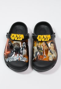 Sabots noirs pour enfants arborant des personnages de Star Wars, notamment des stormtroopers, Rey, Finn, BB-8 et Kylo Ren, avec des brides jaunes portant le logo Star Wars.