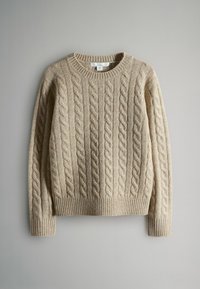 Beżowy sweter z dzianiny w warkocze z ściągaczem przy dekolcie i mankietach. Charakteryzuje się teksturowanym wzorem z wypukłymi warkoczami rozciągającymi się pionowo na tkaninie.