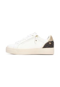 Zapatilla blanca con parte superior texturizada, detalle de cremallera y acento de talón negro con patrón. Presenta una suela crema y herrajes dorados.