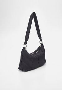 Czarna torebka puffer o miękkiej fakturze, skośnym fasonie, zamykana na zamek, z wyściełanym paskiem na ramię. Akcenty w srebrnym kolorze.