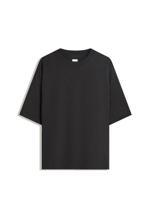 Sort kortærmet T-shirt med rund hals og en afslappet, let oversized pasform, lagt fladt på en hvid overflade.