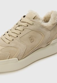 Beidzīga zābaku kedas ar samtainu mīksto apmali, teksturētām šņorēm un gludu gumijas zoli. Diskrēti logo akcenti sānos un mēlītē.