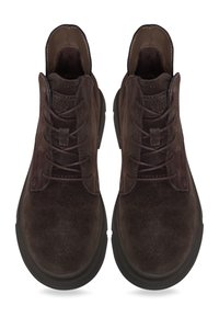 Bottines en daim marron avec une texture lisse, bout rond et semelle en caoutchouc noir. Comprend six œillets de lacets et des détails de couture.