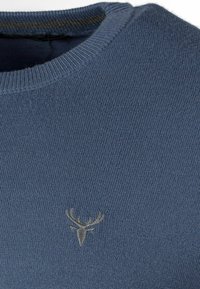 Mėlynas megztinis su apykakle, turintis mažą pilką reljefinį elnio logotipą ant krūtinės. Minkšta tekstūra ir įribiota apykaklė.