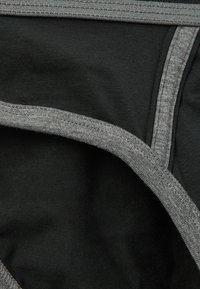 Schwarzes Unterwäschestück mit einer glatten Textur, verstärkten Nähten und einem kontrastierenden grauen Bund mit weichem elastischen Abschluss.