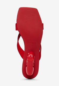 Rote High-Heel-Sandalen mit glänzender Oberfläche, die ein schlankes Design und eine strukturierte Sohle aufweisen. Der Markenname "Desigual" ist eingeprägt.