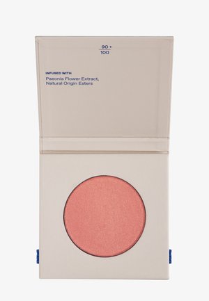 Compact blush in a pale container with a round, shimmery pink pan. Text on packaging includes "Infused with Paeonia Flower Extract."