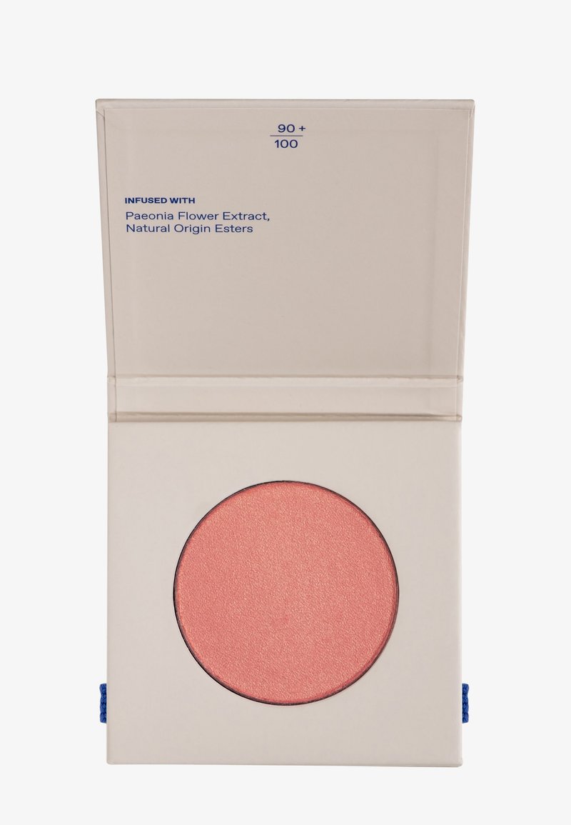 Blush compacto en un envase claro con una bandeja redonda de color rosa brillante. El texto en el embalaje incluye "Infundido con extracto de flor de peonía".