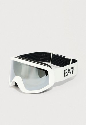 Lyžařské brýle s bílým rámem a zrcadlovými čočkami, černým elastickým páskem s nápisem "EA7" na straně na světlém pozadí.