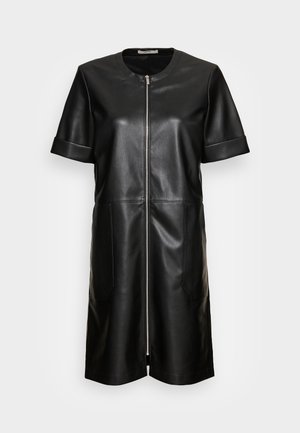 Robe noire en simili cuir à manches courtes avec fermeture éclair frontale et deux poches latérales, dotée d'un col rond et de manches retroussées.