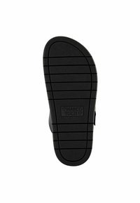 Suela de zapato de goma negra con un patrón de rejilla texturizado y el logotipo "MARCO TOZZI", diseñada para ofrecer agarre y comodidad. Forma plana y redondeada.