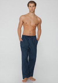 Námořnické modré pruhované kalhoty vyrobené z lehkého materiálu, s elastickým pasem na šňůrku a dvěma bočními kapsami.