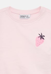 Ροζ ανοιχτό μπλουζάκι για νήπια με στρογγυλή λαιμόκοψη και μικρό σχέδιο φράουλας στο στήθος, ετικέτα με μέγεθος EU 92, US 2T.