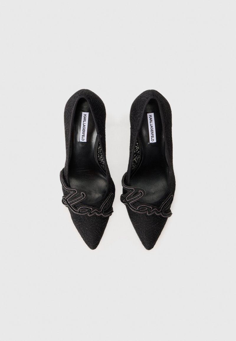 Schwarze High-Heels mit spitzer Zehe, Spitzenstruktur und dekorativem "Karl"-Schriftzug über dem Vorderfuß. Glatte Innenauskleidung.
