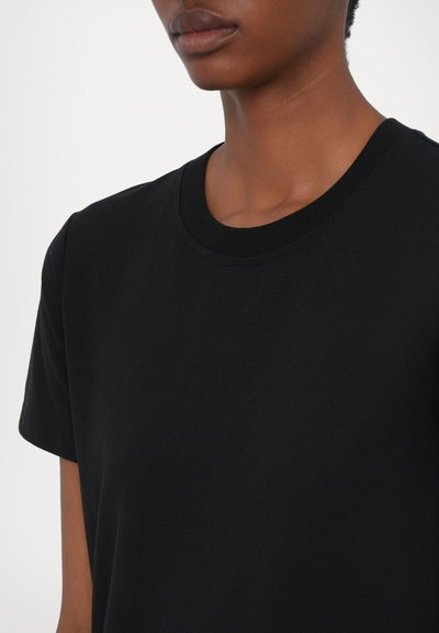 Tricou negru cu mânecă scurtă, realizat din bumbac. Decolteu rotund cu margine cu nervuri. Textură netedă, fără modele sau grafice vizibile.
