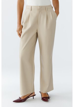 Beige wijde broek met plooien aan de voorkant, een gladde textuur en een getailleerde pasvorm, gecombineerd met bordeauxkleurige gepolijste muiltjes met hak.