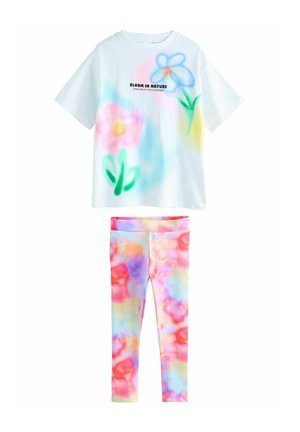 Das Set umfasst ein weißes T-Shirt mit bunten Blumenmotiven und Text, kombiniert mit mehrfarbigen Leggings im Batikmuster.