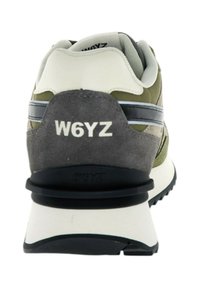 Sneakers con tomaia in suede grigio e verde olive, con accenti a strisce nere e branding bianco sul tallone; suola in gomma nera spessa.