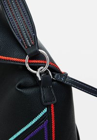Sac en cuir noir avec des coutures contrastées en rouge, bleu clair, violet et orange. Comprend un anneau en argent et une bandoulière ajustable.