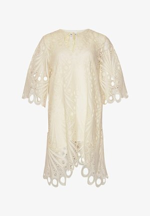 Kreminės spalvos nėriniuota suknelė su apvaliais iškirpimų raštais, banguoto krašto apačia ir plačiomis trumpomis rankovėmis, su mažu surišamu užsegimu ties iškirpte.