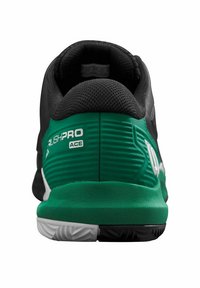 Chaussure de sport noire et verte avec une tige texturée, un col rembourré et un logo bien visible au niveau du talon ; dotée d'une semelle extérieure en caoutchouc durable.