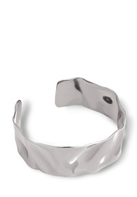 Pulsera de brazalete de plata con un diseño ondulado y texturizado, con extremos abiertos. La superficie lisa y reflectante resalta la forma única.