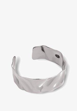 Bracciale in argento con un design ondulato e testurizzato e estremità aperte. La superficie liscia e riflettente mette in risalto la forma unica.