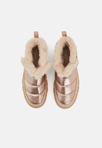 Roza zlata slip-on škornji s kviltanim kovinskim zgornjim delom, umetnim krznom in gumijastim podplatom, s snemnim trakom na peti za enostavno obuvanje.