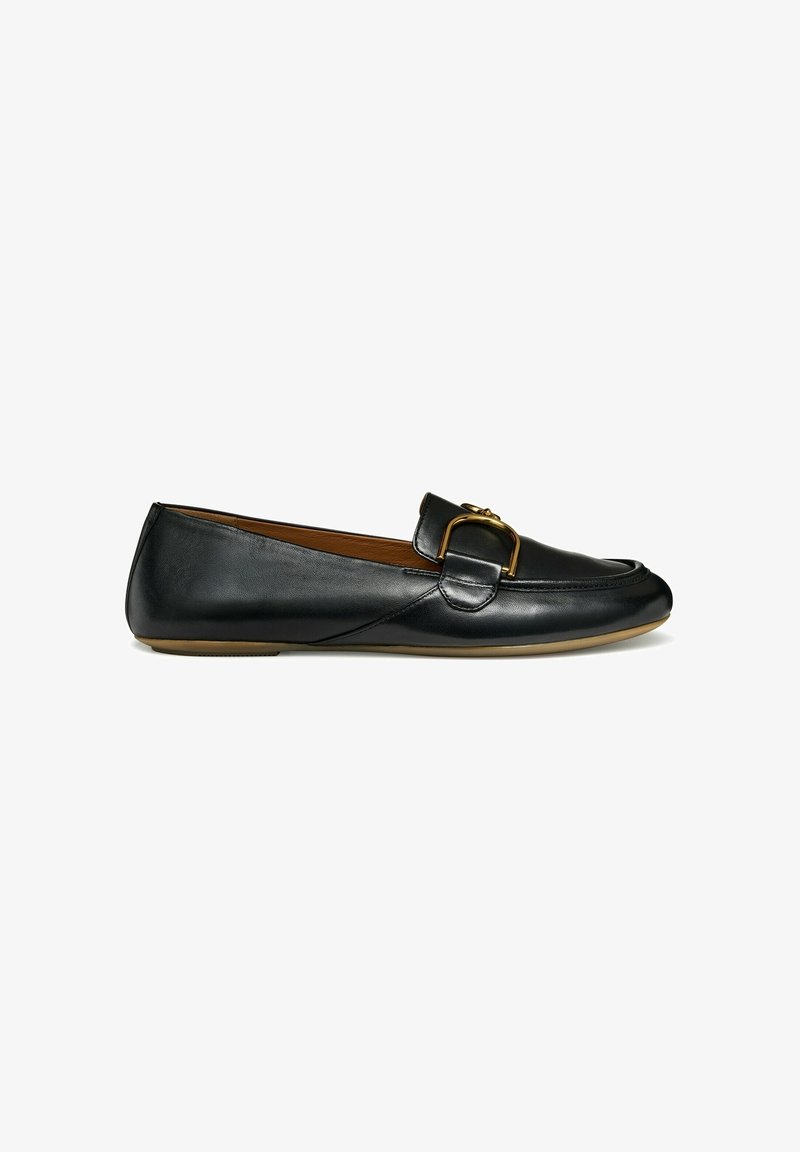 Mocassin en cuir noir avec un détail de boucle en métal doré et une semelle plate beige, vue de côté sur fond blanc.