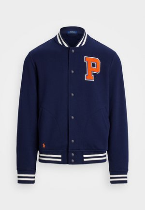 Marineblaue Collegejacke aus weichem Material, mit einem großen orangefarbenen "P"-Patch, weißen gestreiften Bündchen und zwei Fronttaschen.