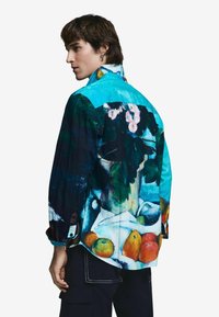 Pánska košeľa na gombíky s výraznou potlačou ovocia a kvetín, s petrolejovým golierom a tmavomodrými rukávmi. Vyrobená z mäkkej látky.