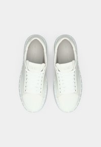Λευκά δερμάτινα αθλητικά παπούτσια με λεία επιφάνεια, στρογγυλεμένη μύτη, επίπεδα κορδόνια και διάφανη λαστιχένια σόλα με διακριτικές κουκκίδες.