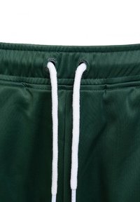 Ceinture élastique vert foncé avec des cordons blancs passés à travers des œillets métalliques sur un pantalon ou un short.