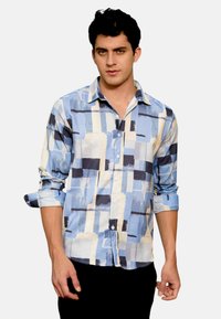 Camicia button-up di colore azzurro chiaro con motivi astratti in navy e beige. Maniche lunghe, polsini arrotolati e colletto. Tessuto liscio.