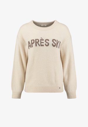 Lichtbeige sweater met ribgebreide zoom en boorden. Heeft 'APRÈS SKI' gebreid in donkerbruin op de voorkant. Zachte textuur, ontspannen pasvorm.