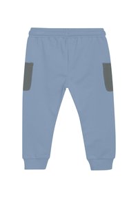 Ljusblåa sweatpants med mjuk textur, elastisk midja och två grå sidofickor. Nederdelarna är avslutade med mudd vilket fulländar designen.