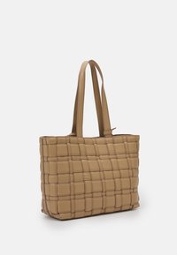 Borsa a spalla intrecciata in beige chiaro, con doppi manici, forma rettangolare e superficie testurizzata con dettagli a motivo a griglia.