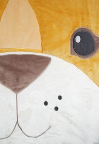 Plush blanket featuring a dog design, primarily yellow and white, with soft textures and black details for eyes and nose.