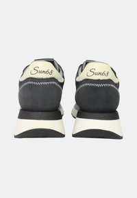 Scarpe da ginnastica nere e grigie con una parte superiore in suede e sintetico, dotate di una linguetta sul tallone crema e del logo "Sun68" sul retro. Suola bianca.