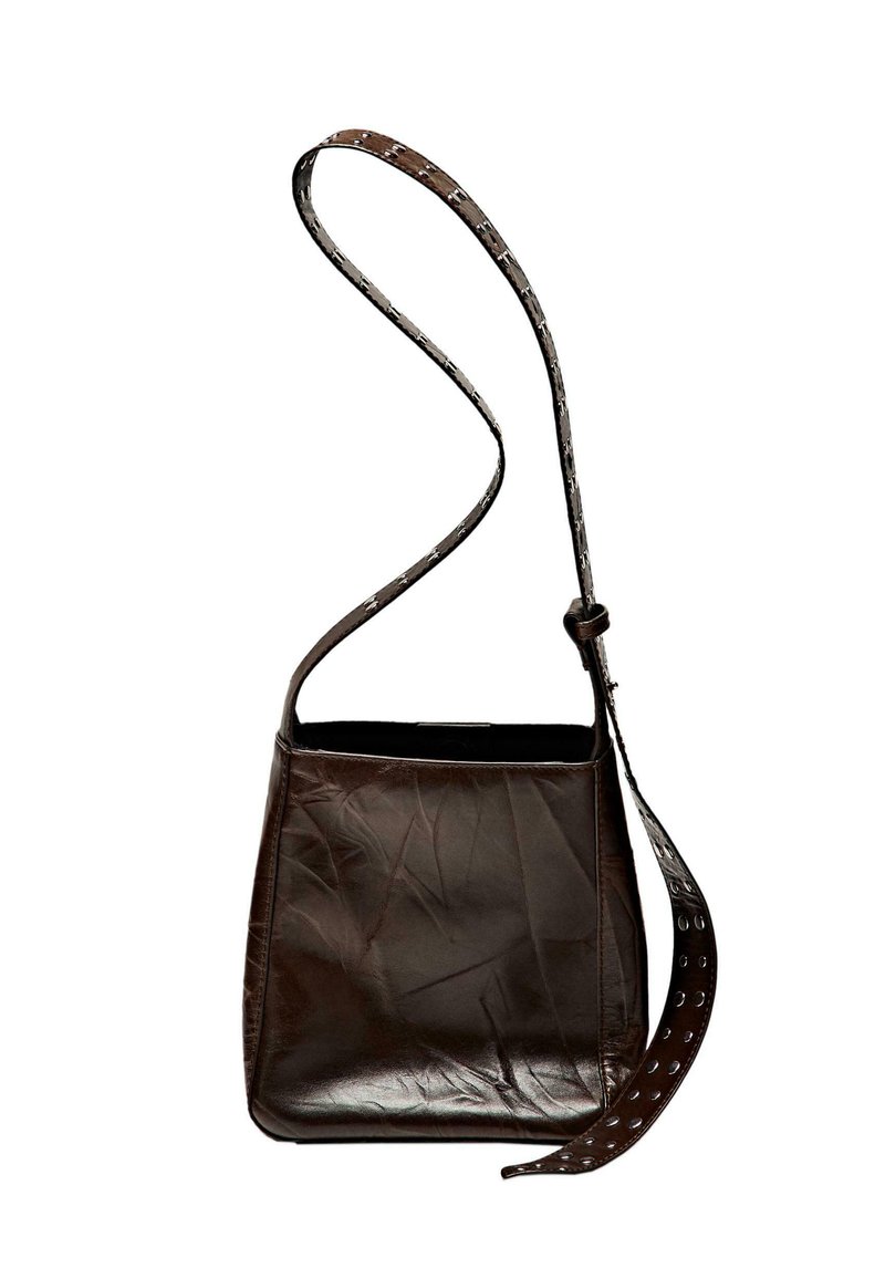 Brown leather shoulder bag with a textured finish, rectangular shape, and a decorative strap featuring circular cut-outs.