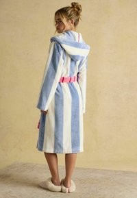 Triibuline sinine ja valge hommikumantel, millel on kapuuts, pikad varrukad ja roosa vöö. Mudel kannab pehmeid sussikesi. Pehme tekstuur.