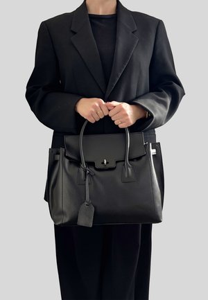 Czarna skórzana torebka o sztywnym kształcie, z górnymi uchwytami, zamknięciem na przedniej klapie i zawieszką. Teksturowana powierzchnia i srebrne akcenty metalowe.