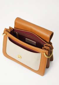 Borsa in pelle color tan con un pannello frontale in tessuto beige, dettagli in metallo dorato e un interno bordeaux. Presenta una tasca con zip e ampi scomparti.